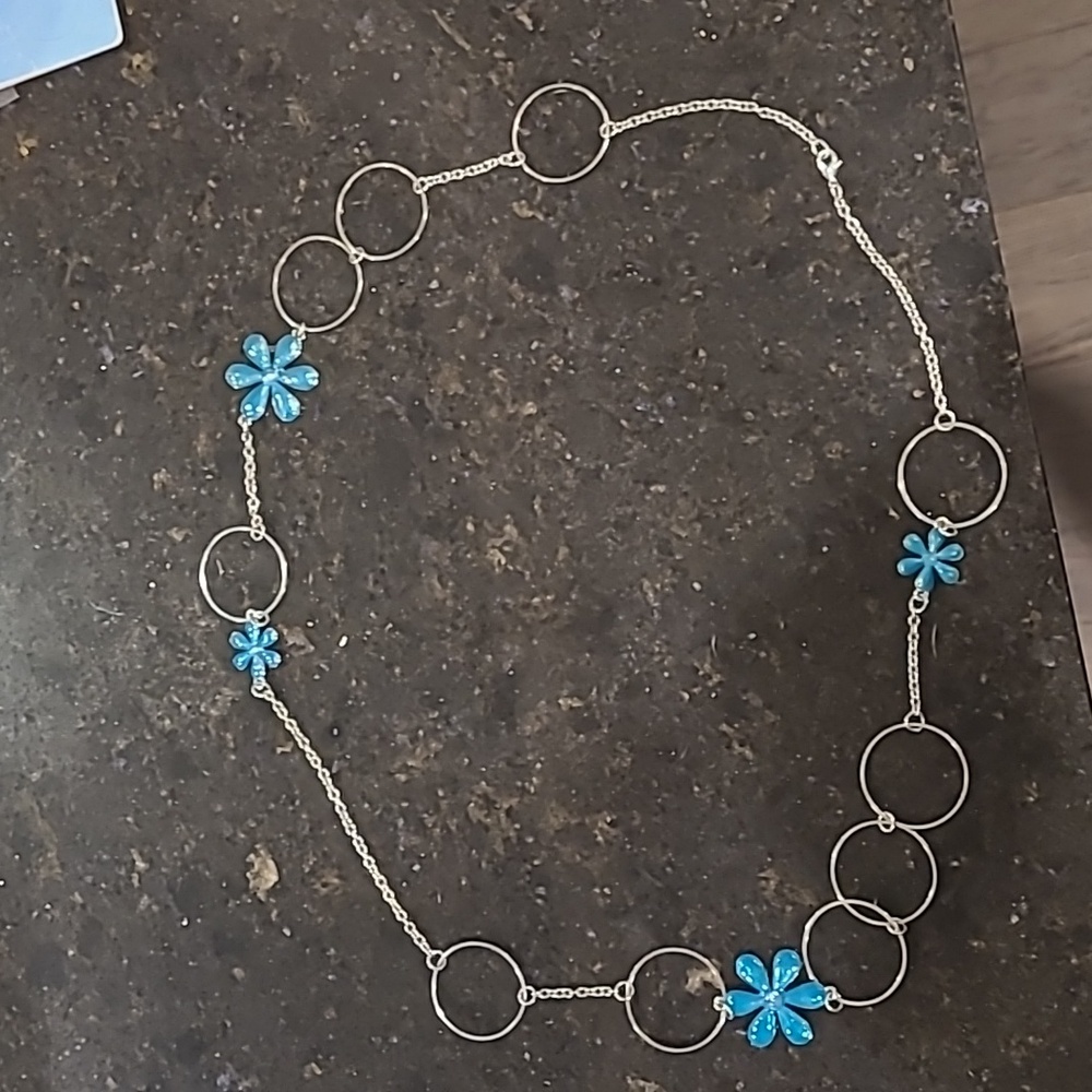 Women's silver colored necklace with turquoise colored flower accents.